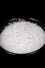 Black bowl of magnesium sulphate showing the white crystals.
