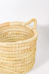 Side view of a medium basket with handles and thick palm rows and rustic natural tone.