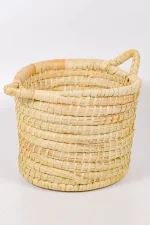 Medium handmade basket with handles and thick palm weave and rounded rope-style finish.