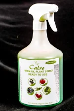 Bottle of Neem Oil for plants displayed with tropical indoor leaves.