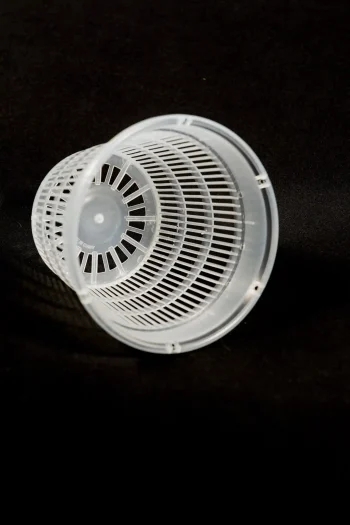 Close-up of transparent net pot with vertical airflow slots.
